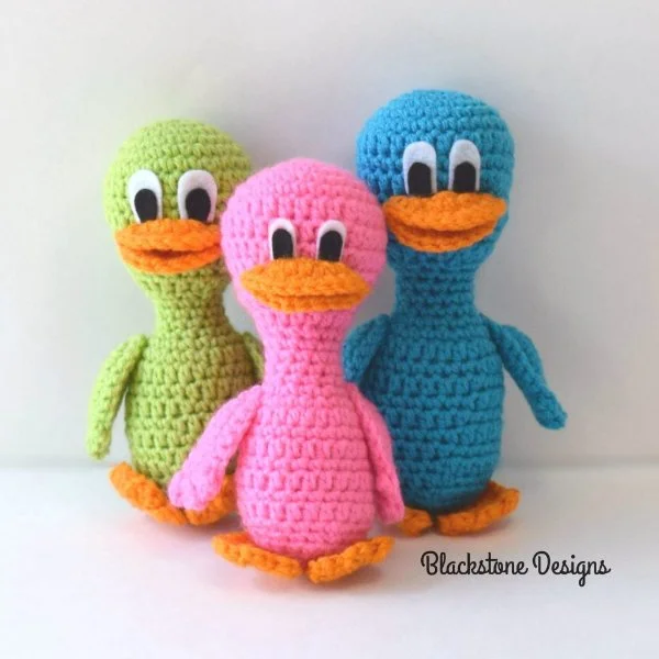 Three cartoon-style crochet ducks made in bright colours.