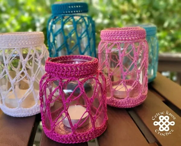 Five mason jars for candles with crochet covers.