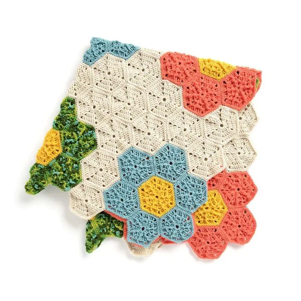 A crochet hexagon blanket with the motifs arranged to look like retro flowers.