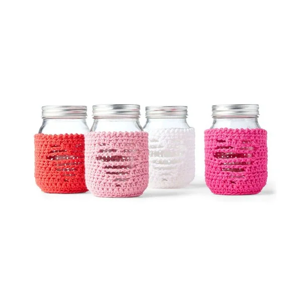Four pink crochet jar cozies with heart motifs.