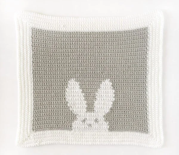A tapestry crochet baby lovey with a bunny motif.