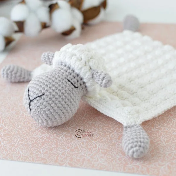 A crochet sheep lovey worked in bobble stitch.