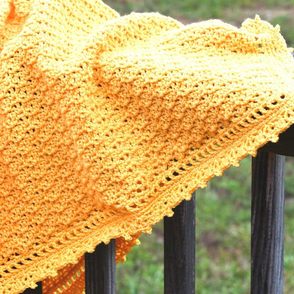 A yellow shell stitvch baby blanket iwth picot edging.