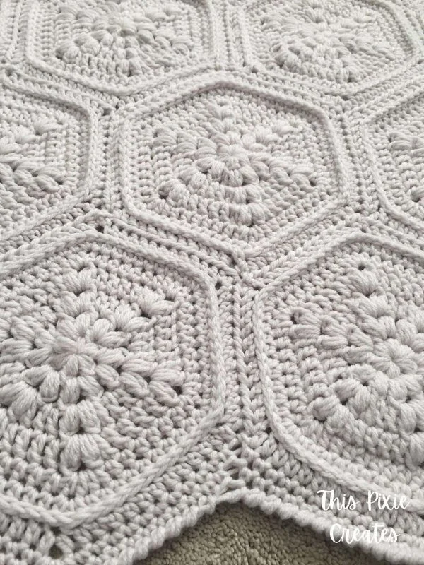 A cream-coloured textured hexagon crochet blanket.