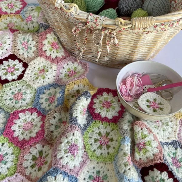 A crochet hexagon blanket made in soft pastels.