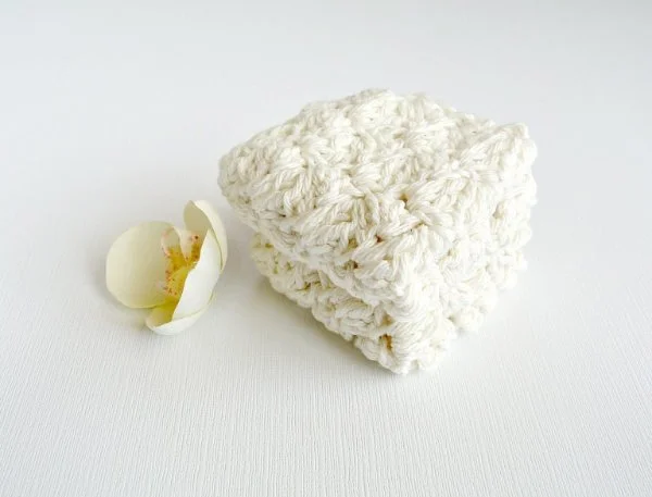 A stack of white crochet washcloths.