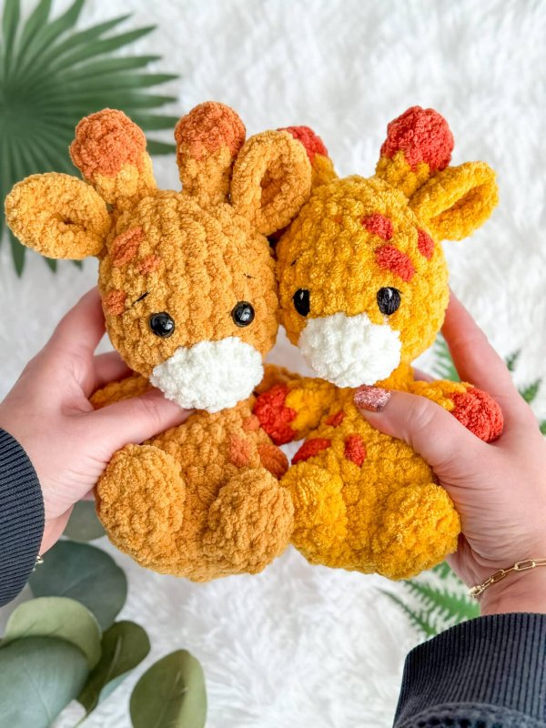 Two mini crochet giraffe toys.
