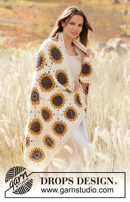 A woman with a sunflower motif granny square blanket draped over her shoulders.