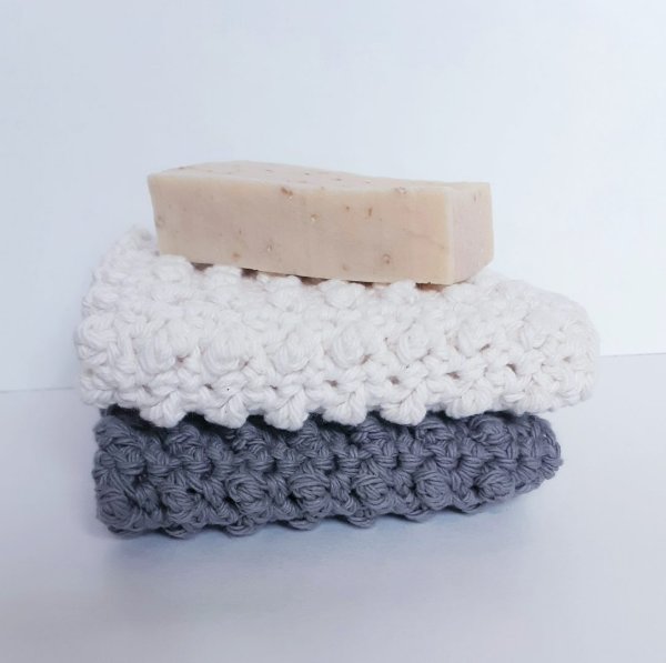Folded crochet washcloths with a bar of soap.