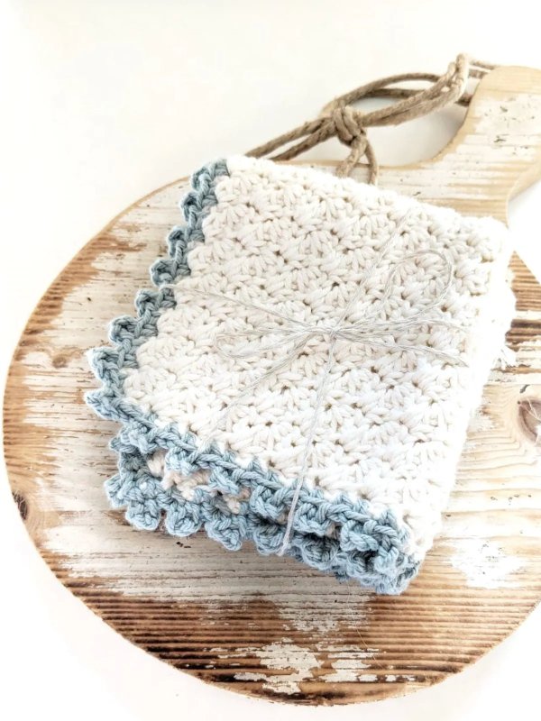 A white crochet washcloth with blue edging.