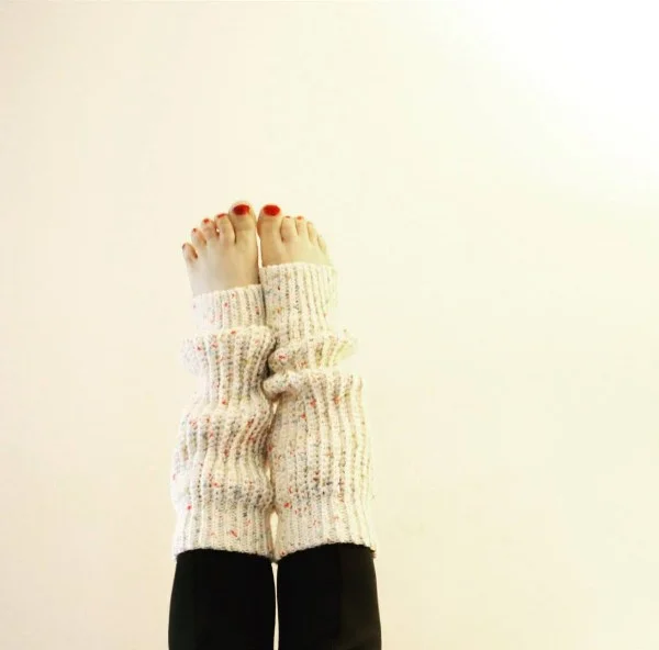 Legs raised in the air weraring crocheted leg warmers.