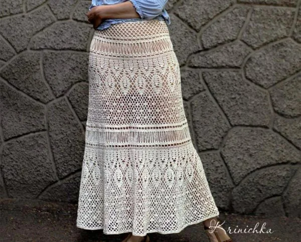 Closeup view of a long crochet skirt with lace stitch patterns.