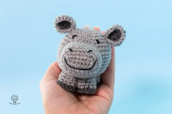 A chubby grey crochet hippo toy.