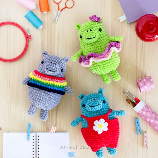 Three small, brightly coloured crochet hippo amigurumis.