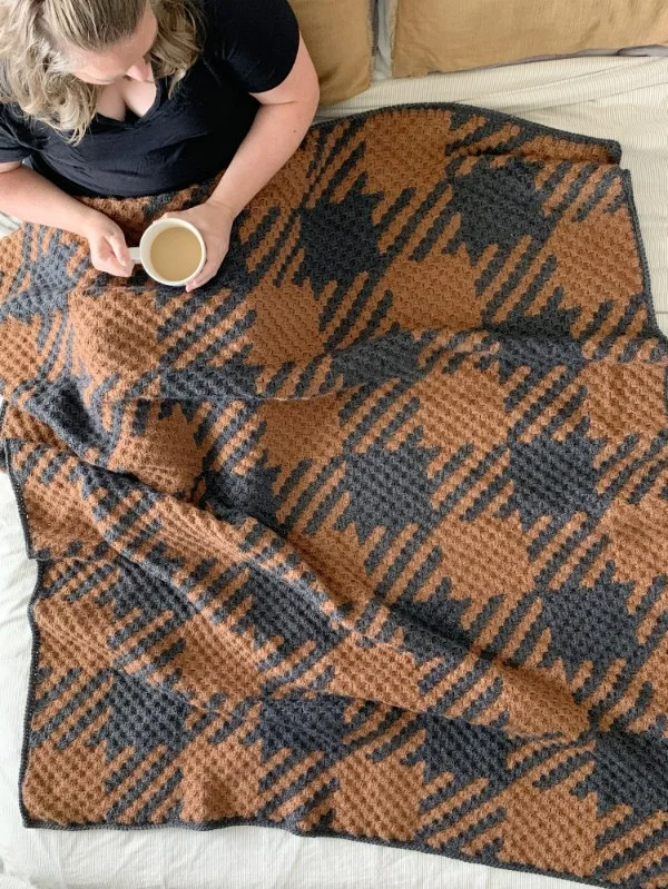A brown and black c2c blanket with a plaid design.