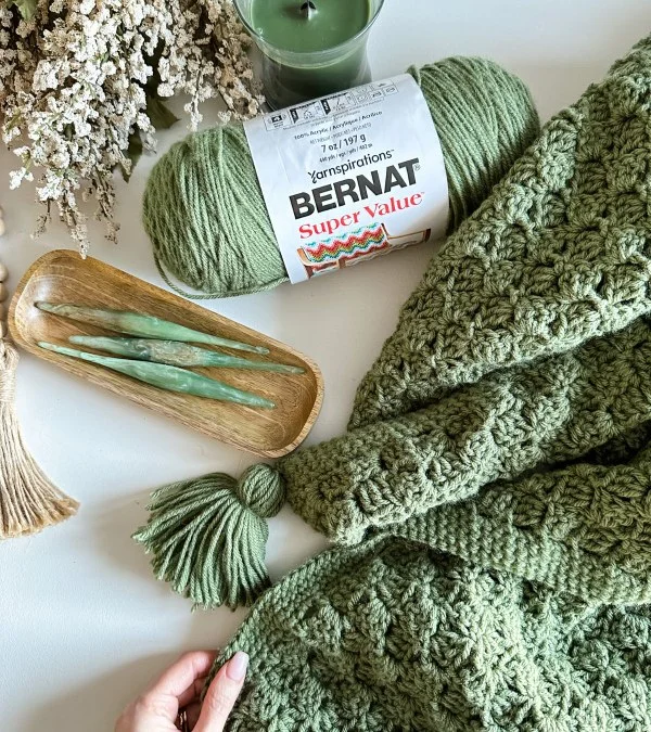 A simple, green c2c blanket and crochet supplies.