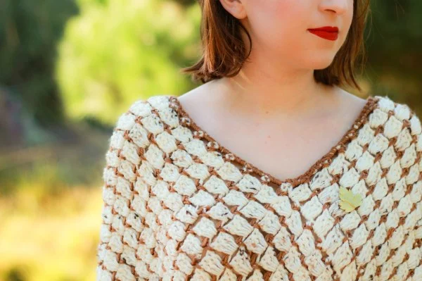 A closeup of a brick stitch crochet poncho.