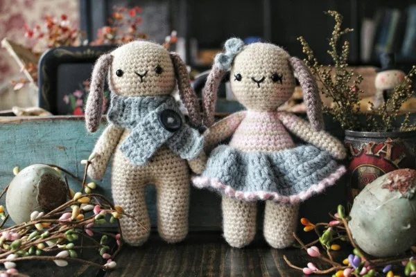 A boy and a girl crochet bunny toys.