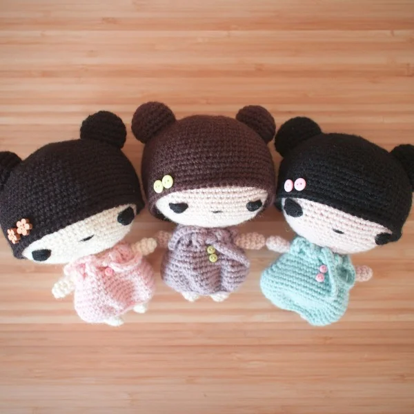 Three versions of a small crochet doll with an oversized head.