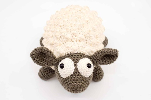 A cute amigurumi sheep with googly eyes.