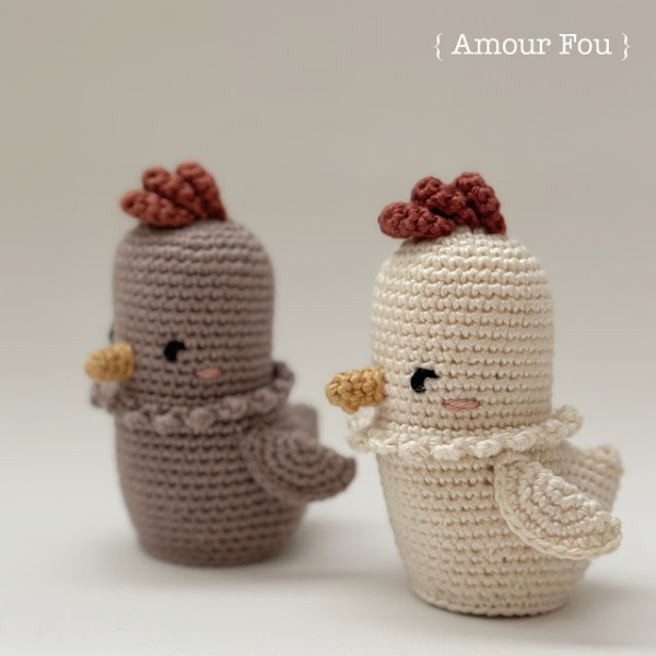 Two crochet hen toys made in soft muted colours.