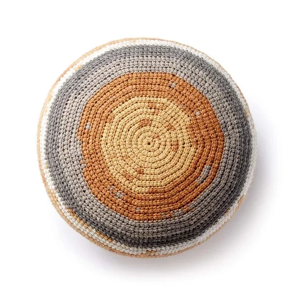 A round crochet pouf worked in cake yarn.