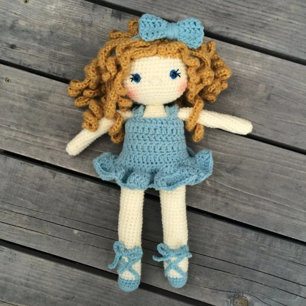 A crochet doll with a blue tutu and ballet shoes.