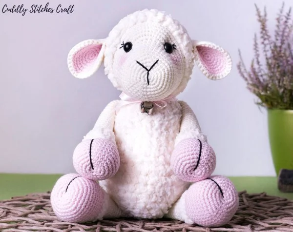 A beautiful soft pink, detailed amigurumi sheep toy.