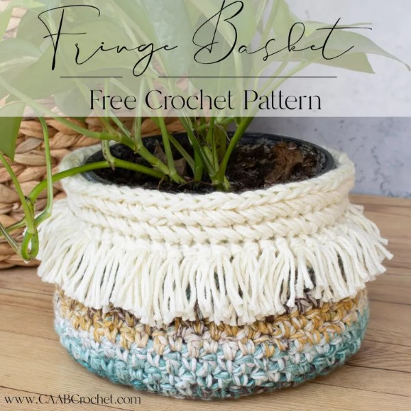 A boho-style fringed crochet plant basket.