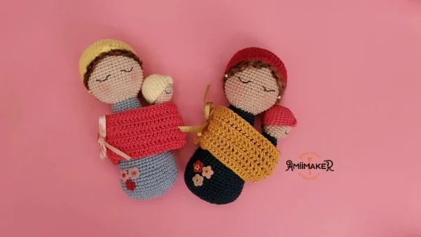 Two crochet dolls with babies in slings.