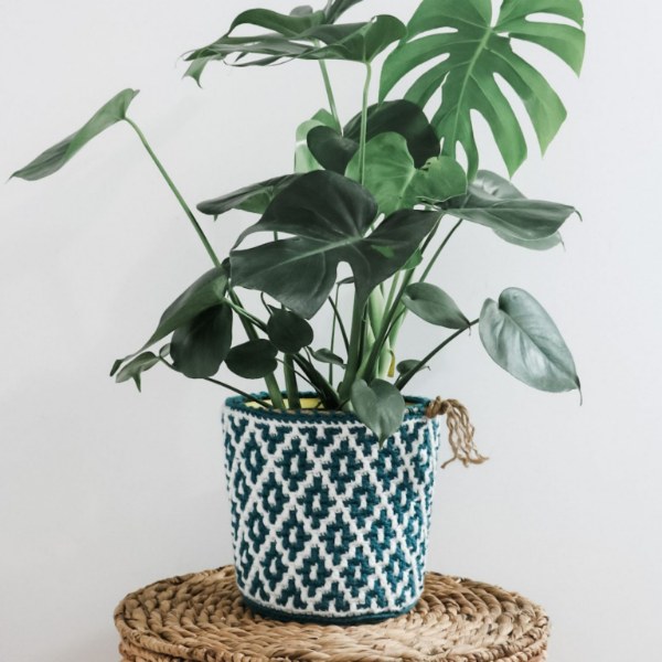 A blue and white mosaic crochet plant pot cover.