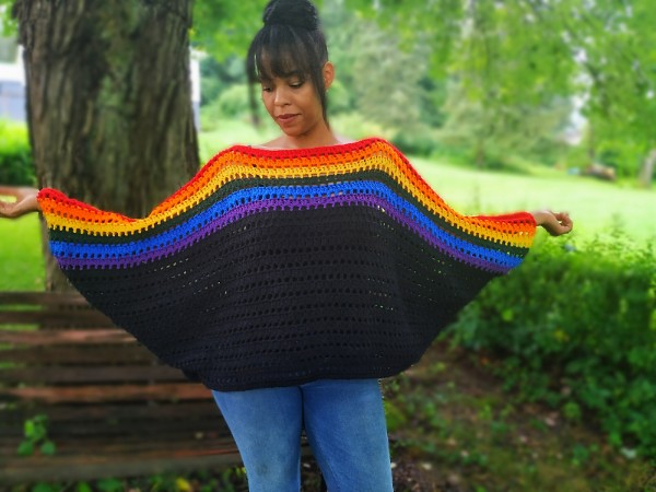 An oversized batwing crochet sweater with rainbow stripes.