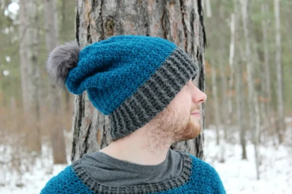 A man wearing a blue and grey slouch-style crochet beanie.