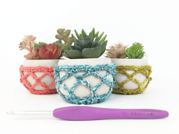 Three succulents in mesh stitch crochet plant baskets.