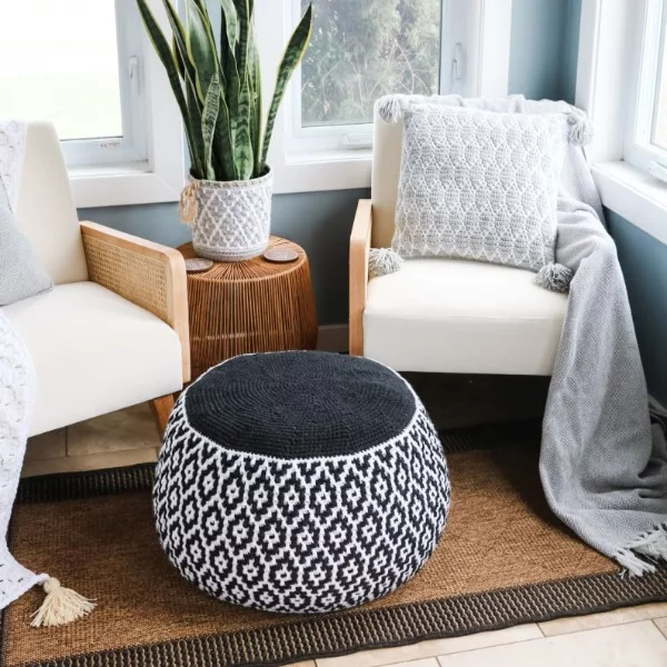 A black and white crochet pouf with a geometric mosaic crochet design.