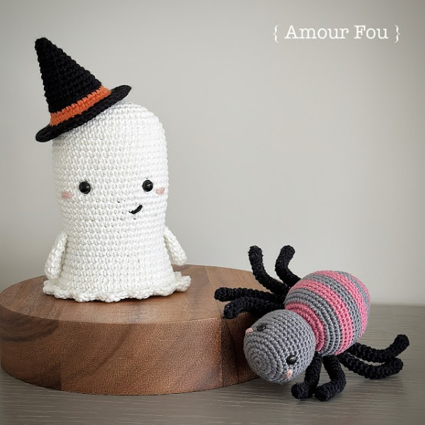 A standing ghost amigurumi next to a crochet spider.