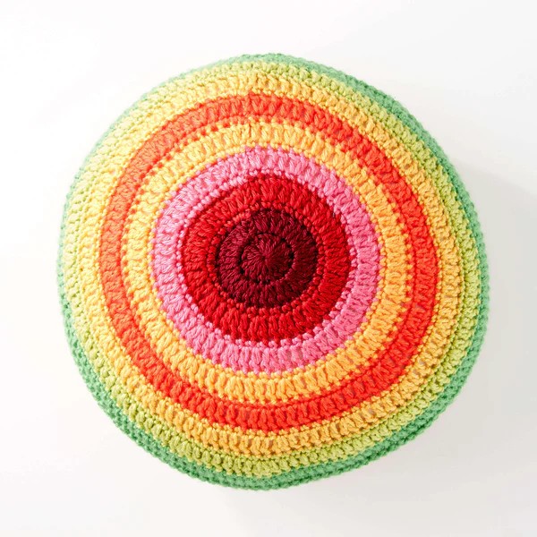 A multicoloured round crochet pillow.
