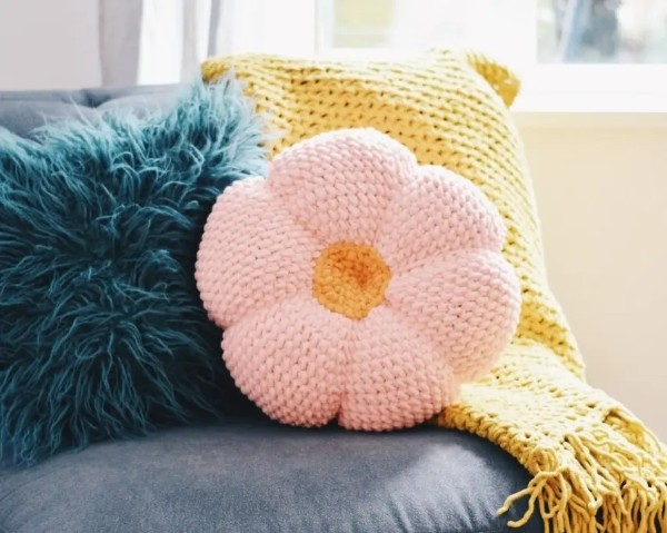 A flower-shaped retro crochet pillow.