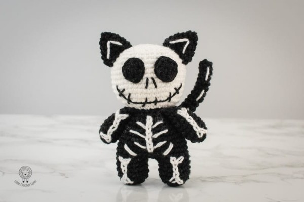 A black and white crochet skeleton cat amigurumi.