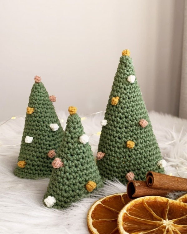 Three crochet Christmas trees with tiny crochet baubles.