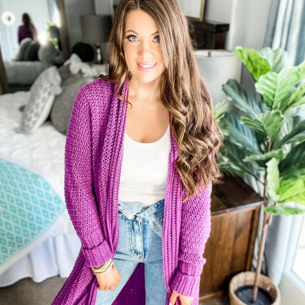 A woman wearing a bright pink crochet duster.