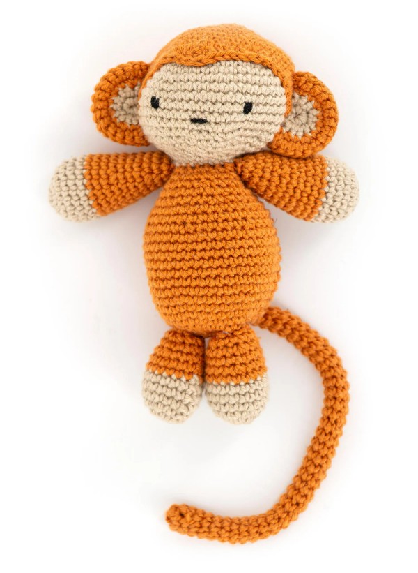 An orange amigurumi monkey toy.