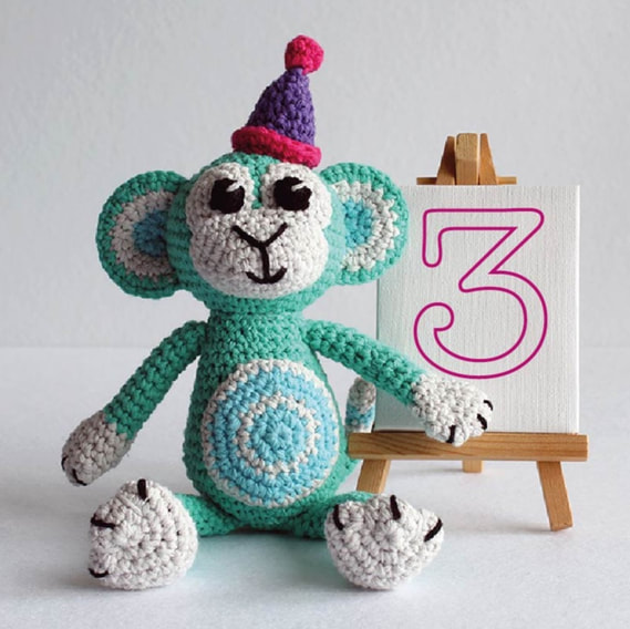 A colourful crochet monkey with a hat.