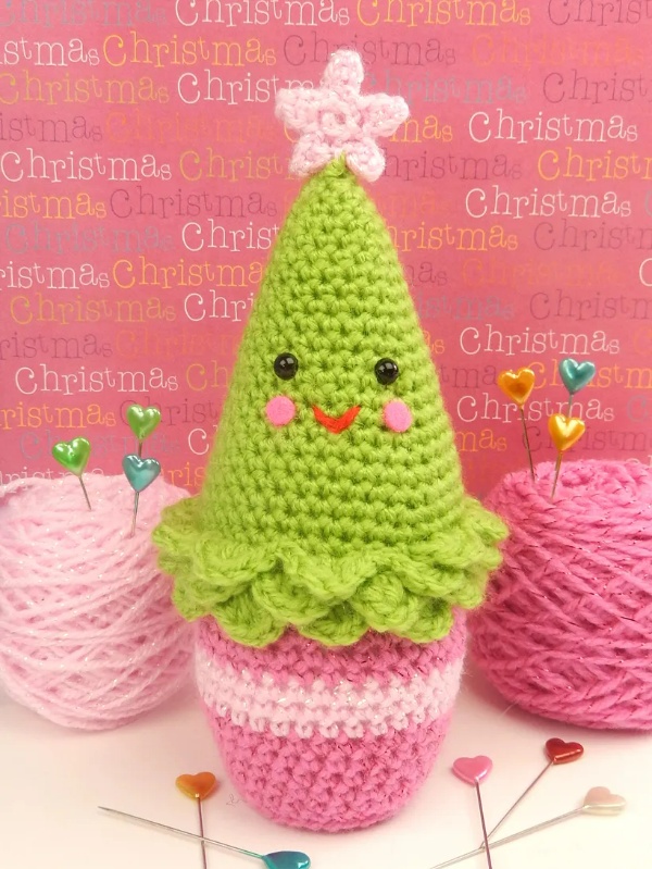 An amigurumi Christmas tree in a pink pot.