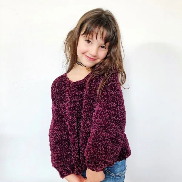 A child wearing a velvet crochet sweater.