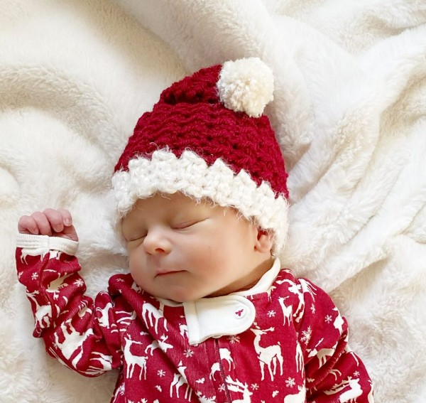 A baby wearing a red Santa hat.