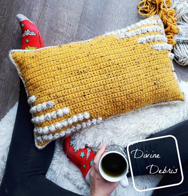 A yellow bobble-stitch pillow with simple contrasting lines.