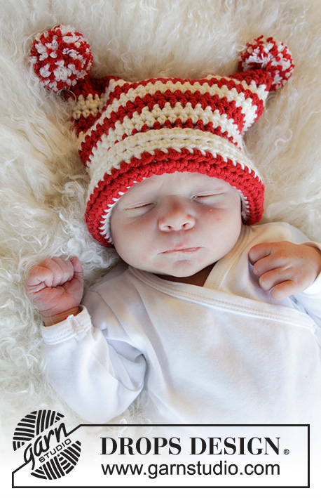 A newborn baby wearing a red and white striped crochet Christmas hat.