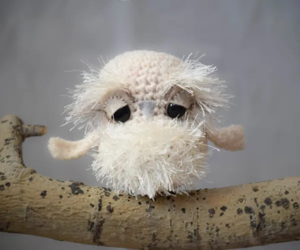 A fluffy, scruffy baby snow owl amigurumi.