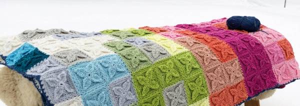 A temperature blanket made with flower granny squares.